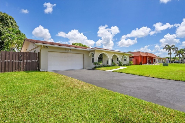 mediterranean / spanish house with stucco siding, a garage, and asphalt driveway