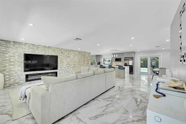 living area with recessed lighting and light marble finish flooring