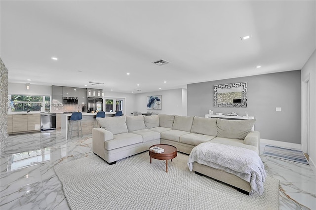 living room featuring light marble finish flooring, plenty of natural light, and recessed lighting