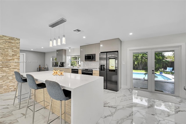 kitchen with black appliances, gray cabinetry, modern cabinets, a breakfast bar, and light countertops