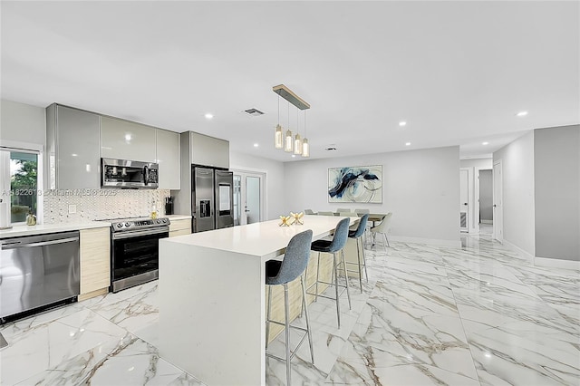 7481 NW 14th St, Plantation, FL 33313 - kitchen featuring stainless steel appliances, gray cabinets, modern cabinets, a breakfast bar area, and tasteful backsplash