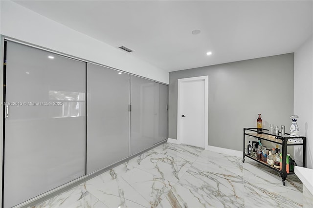 hall with marble look tile flooring and recessed lighting