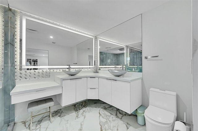 bathroom with double vanity, a marble finish shower, and marble look tile flooring