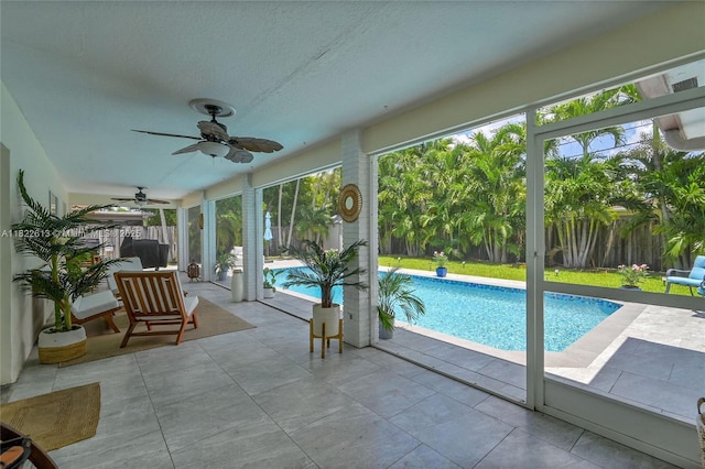 view of swimming pool with ceiling fan, a fenced backyard, and a patio