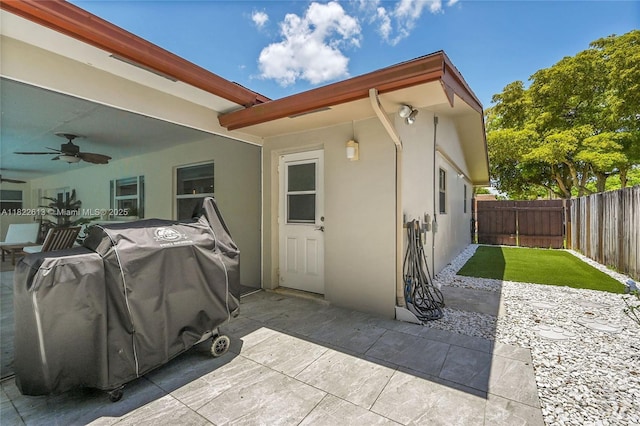 fenced backyard with ceiling fan and a patio