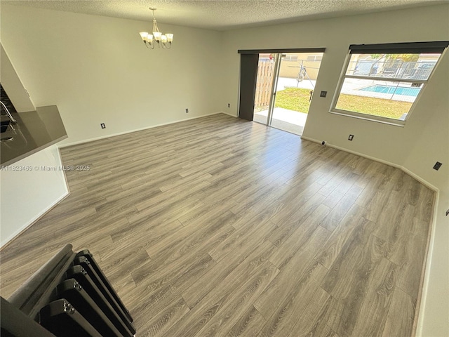 8135 Southgate Blvd, North Lauderdale, FL 33068 - unfurnished living room with a chandelier, wood finished floors, and a textured ceiling