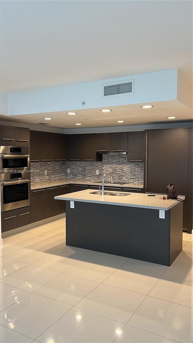 7661 NW 107th Ave Unit 207, Doral, FL 33178 - kitchen featuring modern cabinets, stainless steel double oven, light countertops, dark brown cabinetry, and backsplash