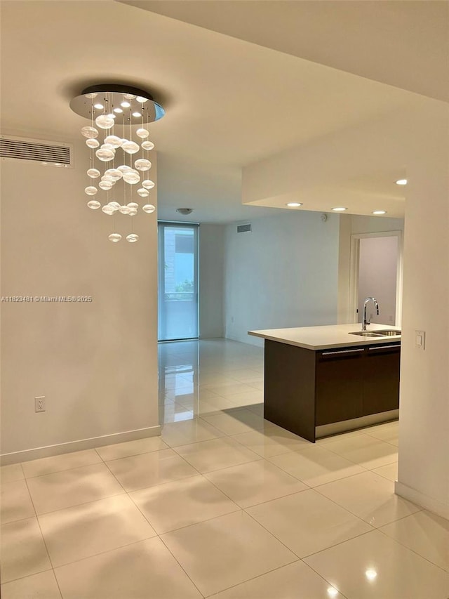 7661 NW 107th Ave Unit 207, Doral, FL 33178 - kitchen featuring light countertops, dark brown cabinetry, hanging light fixtures, and light tile patterned floors