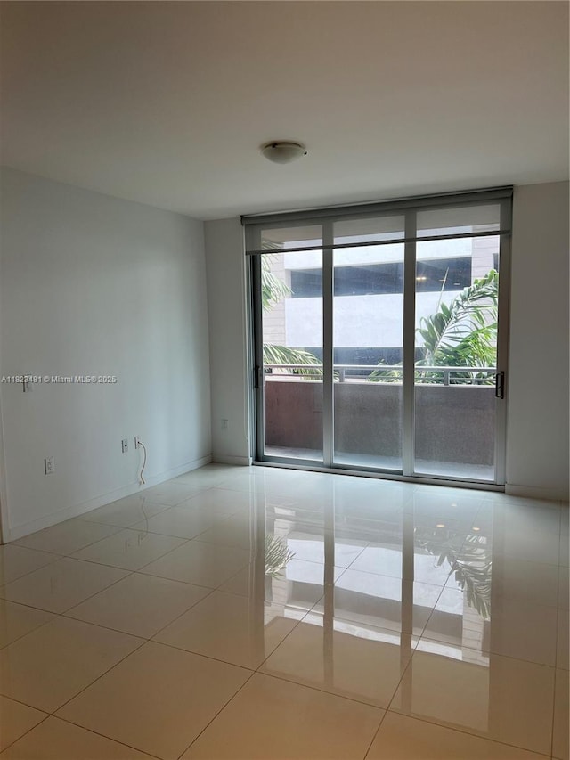 7661 NW 107th Ave Unit 207, Doral, FL 33178 - empty room with plenty of natural light, tile patterned floors, and a wall of windows