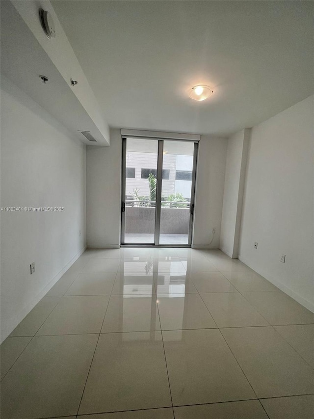 7661 NW 107th Ave Unit 207, Doral, FL 33178 - unfurnished room featuring light tile patterned flooring and a wall of windows