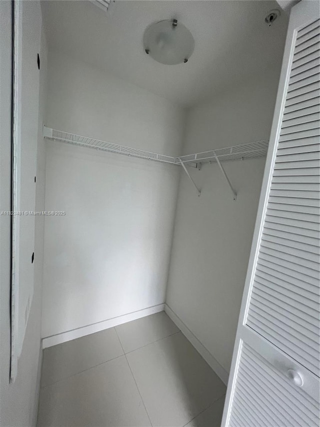7661 NW 107th Ave Unit 207, Doral, FL 33178 - walk in closet featuring tile patterned flooring
