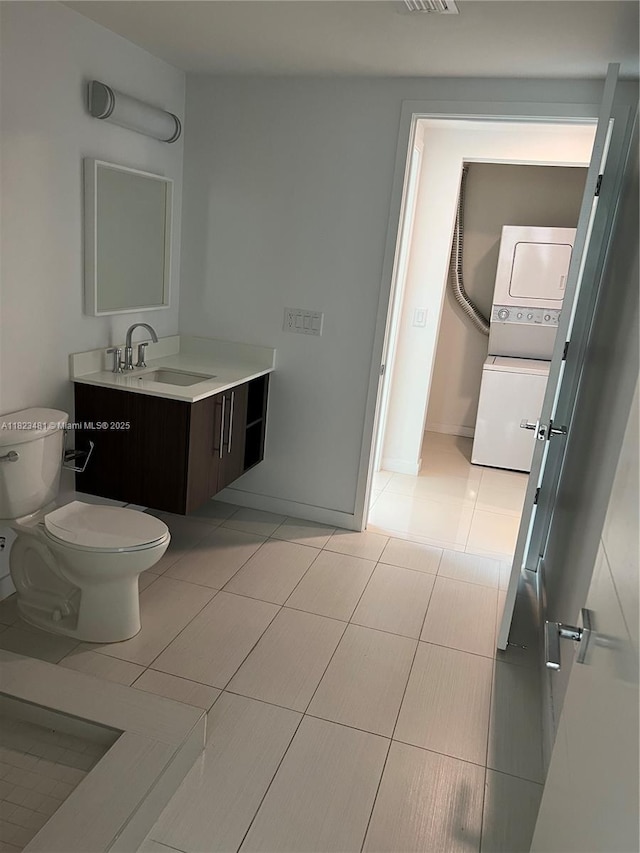 7661 NW 107th Ave Unit 207, Doral, FL 33178 - bathroom featuring stacked washer and clothes dryer, vanity, and tile patterned flooring