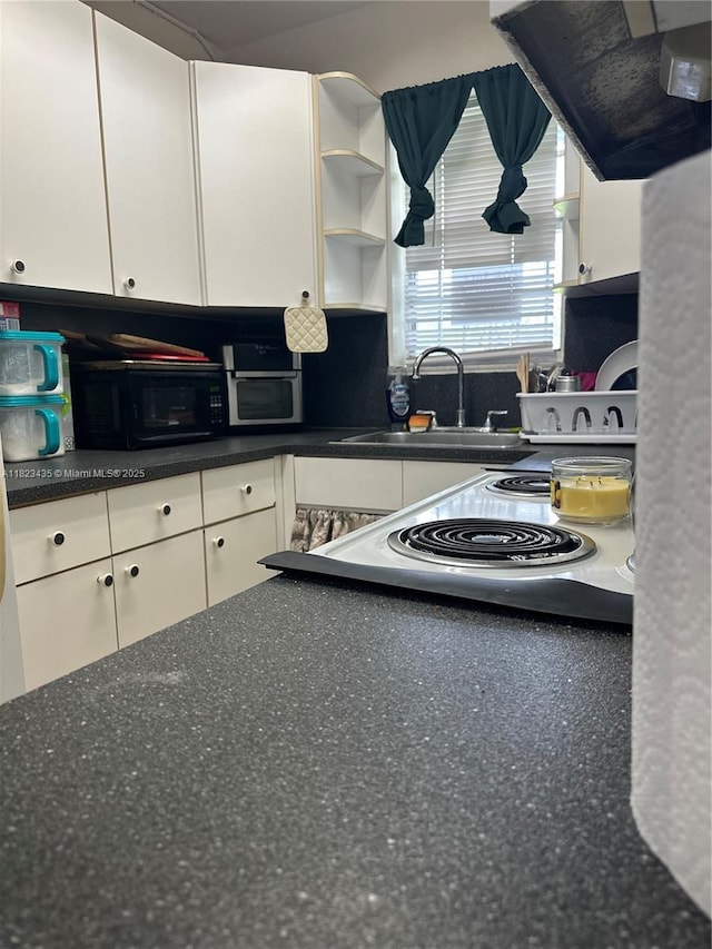 4050 NW 135th St Unit 8-9, Opa-Locka, FL 33054 - kitchen featuring open shelves, exhaust hood, white cabinets, and black microwave