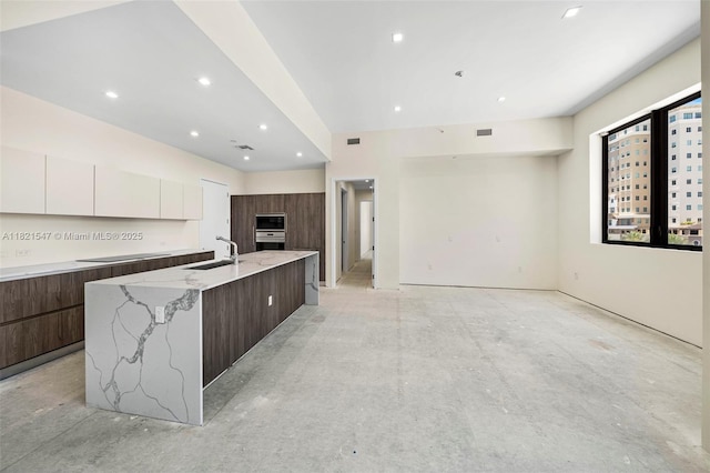 275 Giralda Ave Unit 6A-B, Coral Gables, FL 33134 - kitchen featuring modern cabinets, oven, white cabinets, concrete floors, and a large island