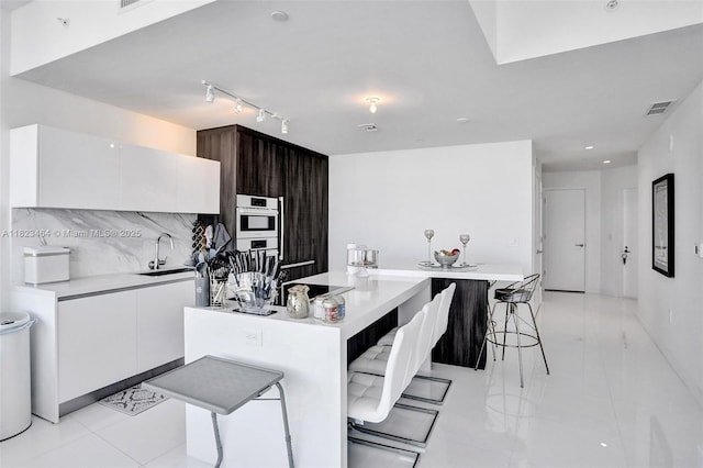 851 NE 1st Ave Unit 2204, Miami, FL 33132 - kitchen featuring rail lighting, modern cabinets, white cabinets, and light countertops