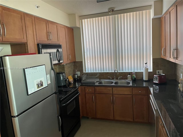 2000 N Bayshore Dr Unit 201, Miami, FL 33137 - kitchen featuring stainless steel appliances, brown cabinets, decorative backsplash, and light tile patterned flooring