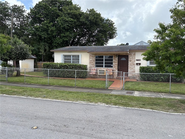 4780 NW 18th Ave, Miami, FL 33142 - ranch-style house featuring stone siding, a fenced front yard, stucco siding, and a gate
