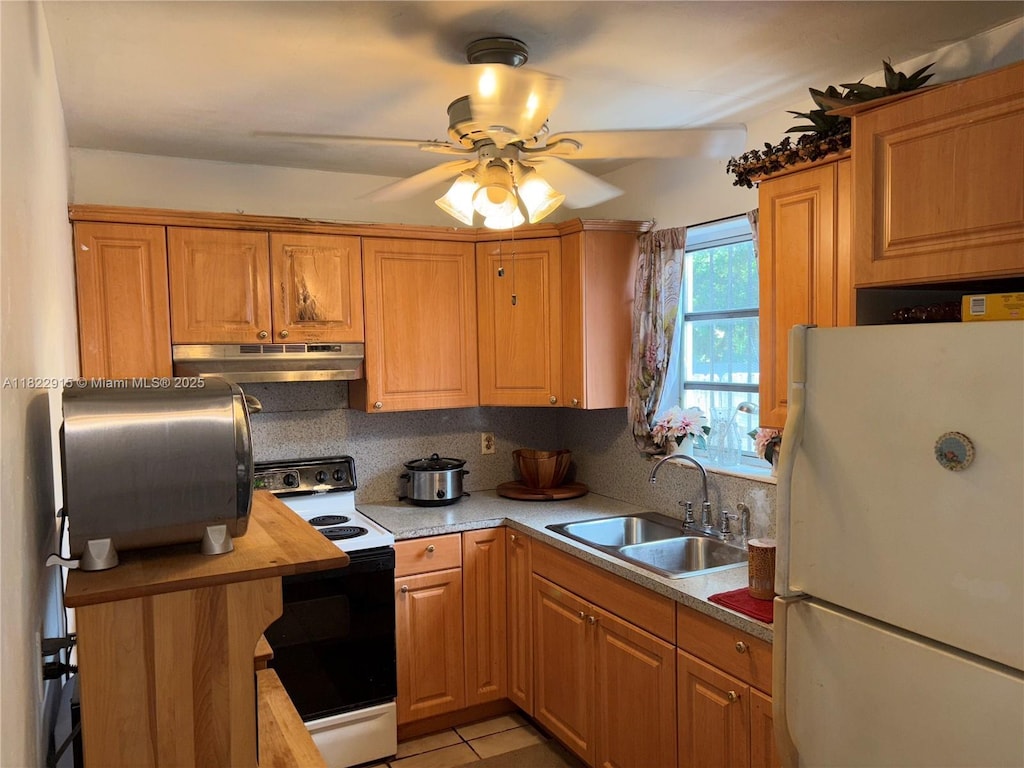 4780 NW 18th Ave, Miami, FL 33142 - kitchen with white appliances, under cabinet range hood, a ceiling fan, decorative backsplash, and light countertops