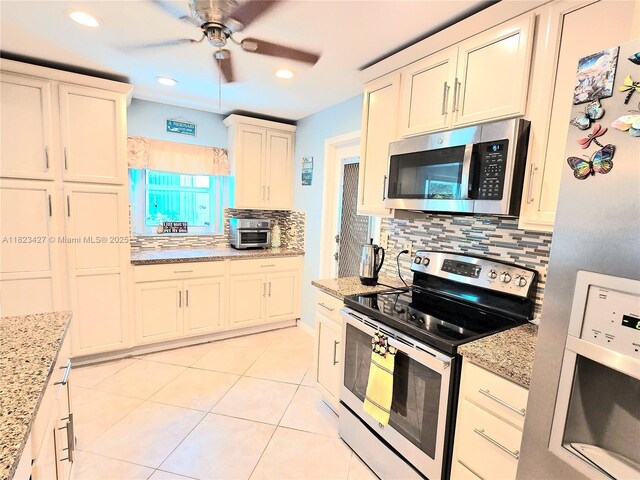1711 SW 22nd St, Boynton Beach, FL 33426 - kitchen featuring stainless steel appliances, decorative backsplash, ceiling fan, light tile patterned flooring, and white cabinets