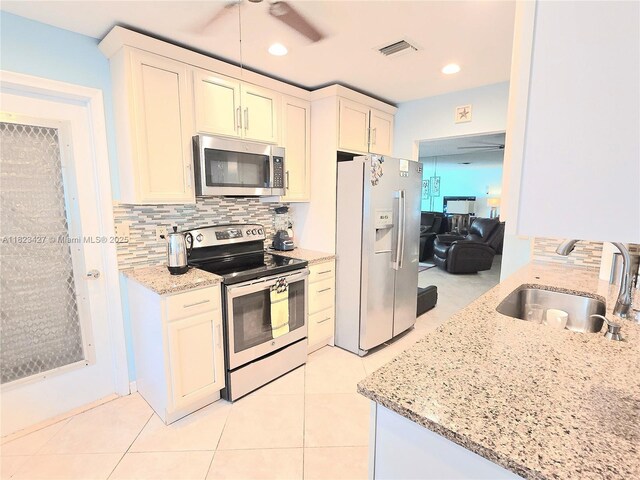 1711 SW 22nd St, Boynton Beach, FL 33426 - kitchen featuring appliances with stainless steel finishes, light stone counters, backsplash, light tile patterned floors, and recessed lighting