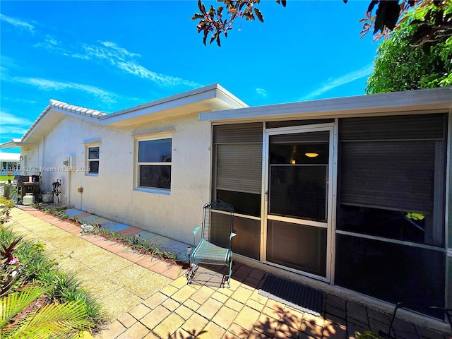1711 SW 22nd St, Boynton Beach, FL 33426 - view of side of property featuring stucco siding and a patio