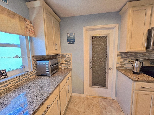 1711 SW 22nd St, Boynton Beach, FL 33426 - kitchen with backsplash, dark stone counters, and light tile patterned floors