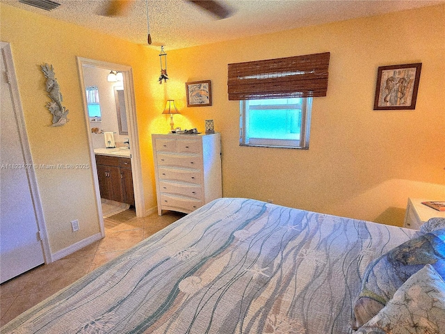 1711 SW 22nd St, Boynton Beach, FL 33426 - bedroom with light tile patterned floors, connected bathroom, and a textured ceiling