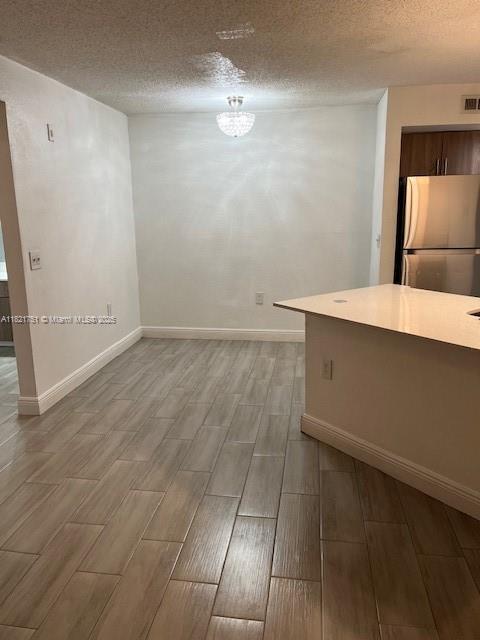 12950 Vista Isles Dr Unit 414, Sunrise, FL 33325 - unfurnished dining area with wood finish floors and a textured ceiling