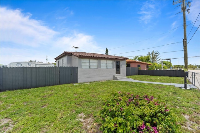 6474 Palm Ave, Hialeah, FL 33012 - back of house with entry steps, a fenced backyard, brick siding, and a tile roof
