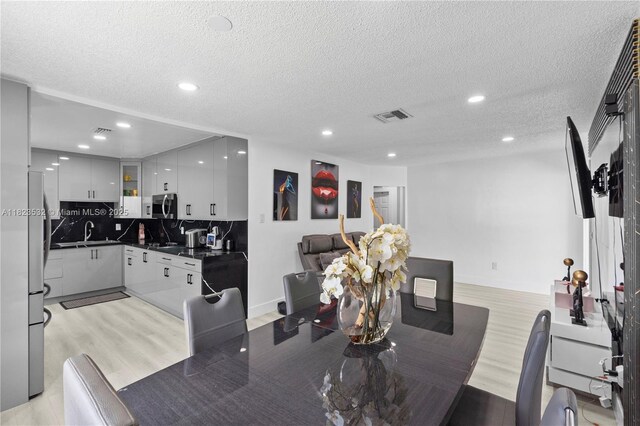 6474 Palm Ave, Hialeah, FL 33012 - dining space featuring light wood-style flooring, recessed lighting, and a textured ceiling
