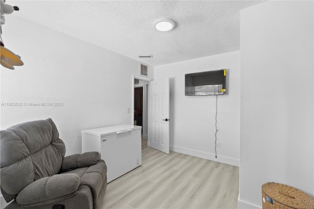 6474 Palm Ave, Hialeah, FL 33012 - sitting room with light wood-style flooring and a textured ceiling
