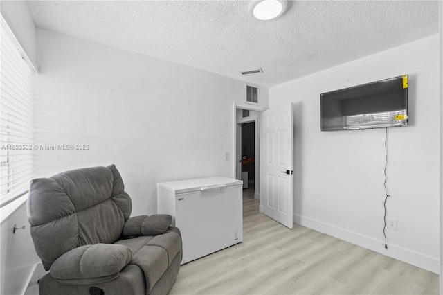 6474 Palm Ave, Hialeah, FL 33012 - living area featuring light wood-style flooring and a textured ceiling
