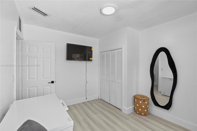 6474 Palm Ave, Hialeah, FL 33012 - bedroom featuring light wood-type flooring, a textured ceiling, and a closet