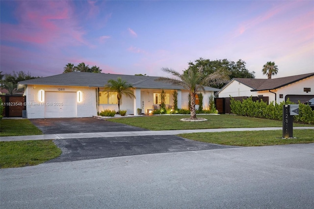 12811 SW 9th Pl, Davie, FL 33325 - ranch-style house featuring a garage, asphalt driveway, a lawn, and stucco siding