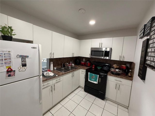 5705 W 20th Ave Unit 310, Hialeah, FL 33012 - kitchen featuring freestanding refrigerator, stainless steel microwave, black range with electric stovetop, decorative backsplash, and dark countertops