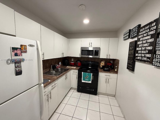 5705 W 20th Ave Unit 310, Hialeah, FL 33012 - kitchen with freestanding refrigerator, stainless steel microwave, black range with electric cooktop, dark countertops, and decorative backsplash