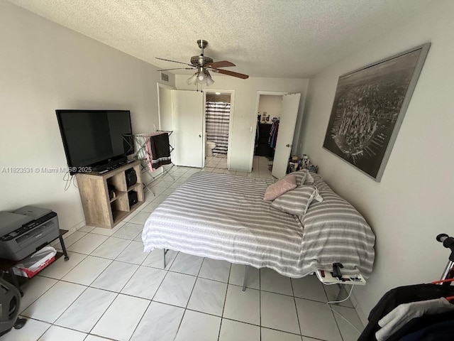 5705 W 20th Ave Unit 310, Hialeah, FL 33012 - tiled bedroom featuring a textured ceiling, a spacious closet, a closet, ensuite bath, and a ceiling fan