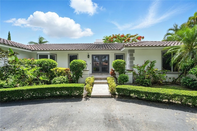 13454 SW 58th Ave, Pinecrest, FL 33156 - view of front facade with french doors, a tile roof, and stucco siding