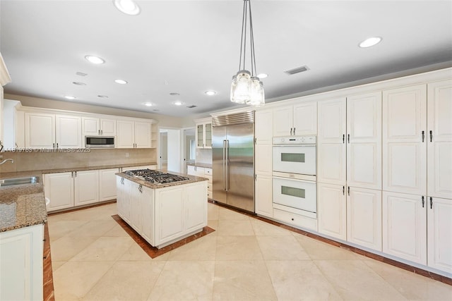 13454 SW 58th Ave, Pinecrest, FL 33156 - kitchen featuring stainless steel appliances, stone counters, white cabinets, recessed lighting, and decorative light fixtures