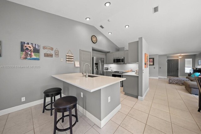 490 Talavera Rd, Weston, FL 33326 - kitchen featuring gray cabinets, stainless steel appliances, light tile patterned floors, a breakfast bar, and light countertops