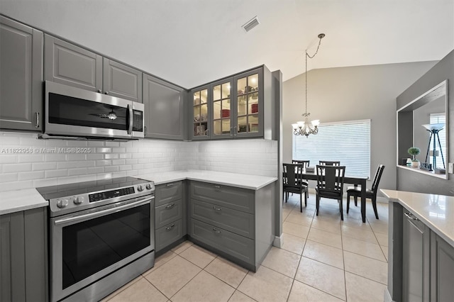 490 Talavera Rd, Weston, FL 33326 - kitchen featuring appliances with stainless steel finishes, gray cabinets, lofted ceiling, decorative backsplash, and glass insert cabinets