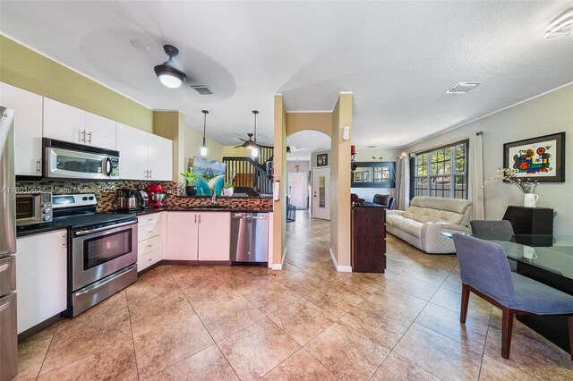 3869 NW 92nd Ave, Sunrise, FL 33351 - kitchen with stainless steel appliances, dark countertops, decorative backsplash, a ceiling fan, and white cabinets