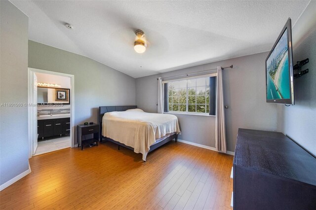3869 NW 92nd Ave, Sunrise, FL 33351 - bedroom with light wood-style floors, vaulted ceiling, ceiling fan, and ensuite bathroom