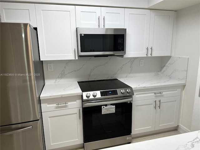 15221 SW 80th St Unit 304, Miami, FL 33193 - kitchen with stainless steel appliances, white cabinets, light stone counters, and tasteful backsplash