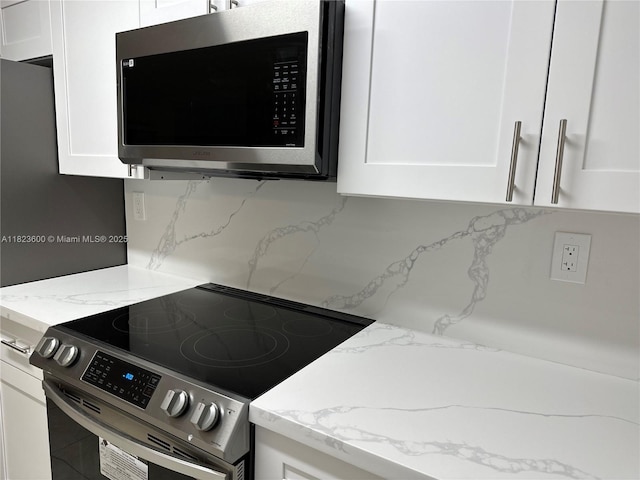 15221 SW 80th St Unit 304, Miami, FL 33193 - detailed view of appliances with stainless steel finishes, tasteful backsplash, white cabinetry, and light stone countertops