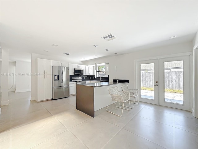 4996 SW 95th Ave, Cooper City, FL 33328 - kitchen featuring stainless steel appliances, french doors, white cabinets, a peninsula, and decorative light fixtures