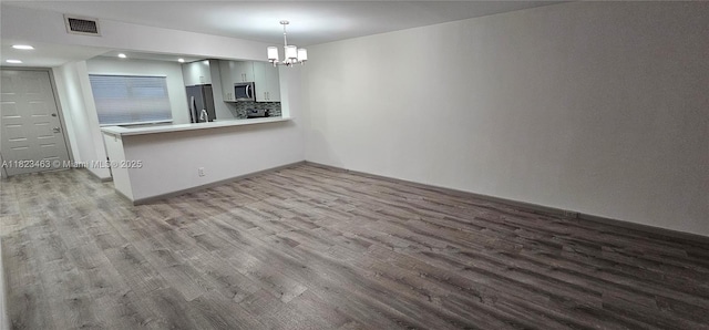 100 SW 130th Ter Unit 309C, Pembroke Pines, FL 33027 - kitchen with stainless steel appliances, wood finished floors, a chandelier, light countertops, and recessed lighting