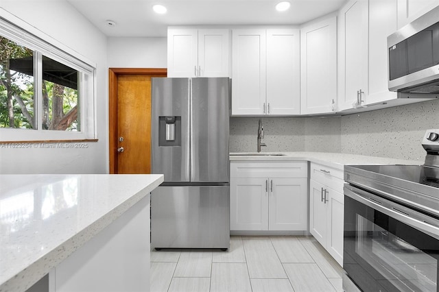 7700 SW 56th Ave Unit 2, Miami, FL 33143 - kitchen with appliances with stainless steel finishes, white cabinets, light stone countertops, and recessed lighting