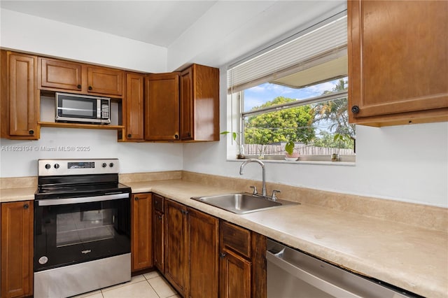 8851 NW 12th St, Pembroke Pines, FL 33024 - kitchen with stainless steel appliances, light countertops, light tile patterned flooring, and brown cabinets
