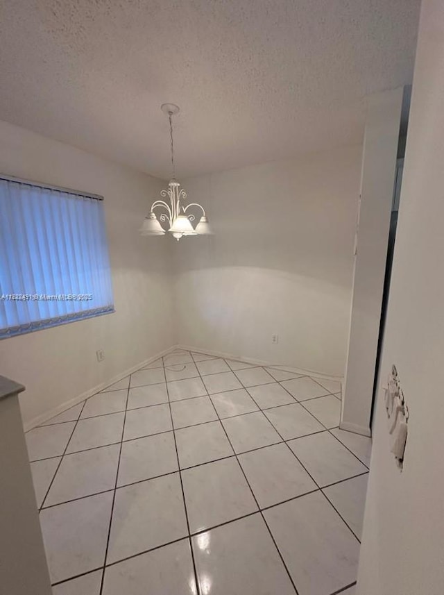 9587 Weldon Cir Unit B203, Tamarac, FL 33321 - spare room featuring light tile patterned floors, a chandelier, and a textured ceiling